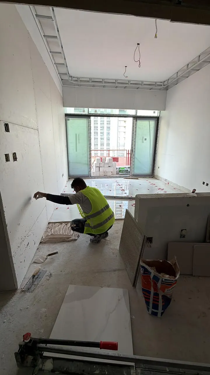 Technician preparing and making good a wall surface before finishes