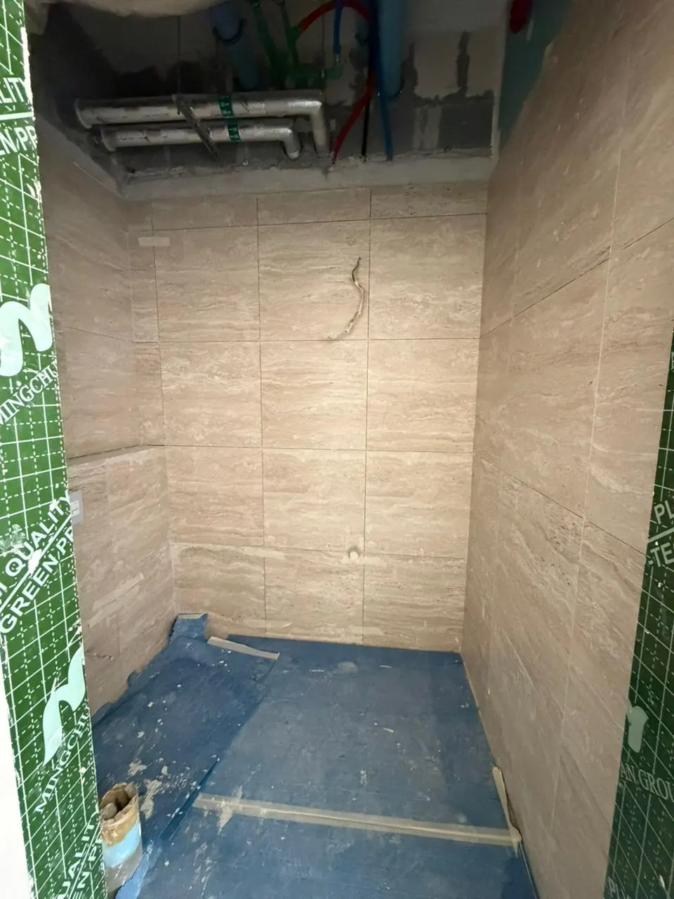 Wet area with walls fully tiled and the floor waterproofing membrane still exposed